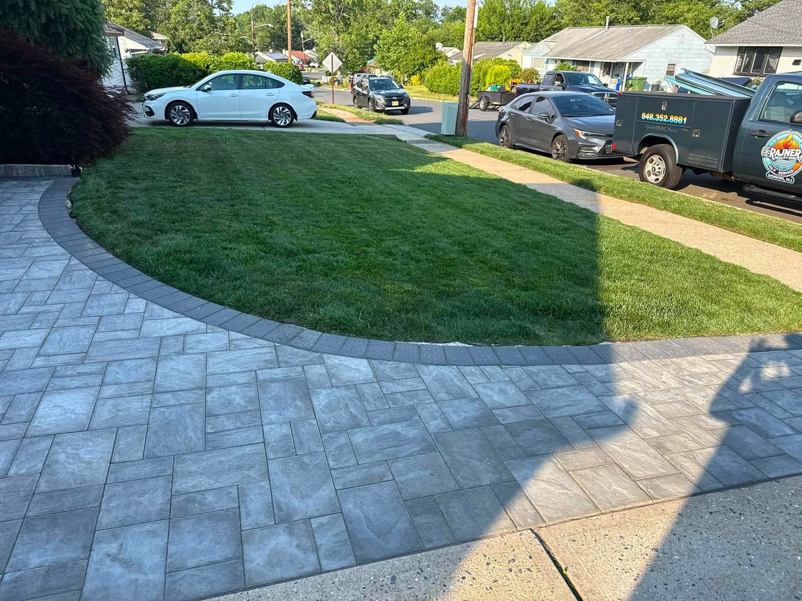 Freshly maintained front lawn beside paver driveway